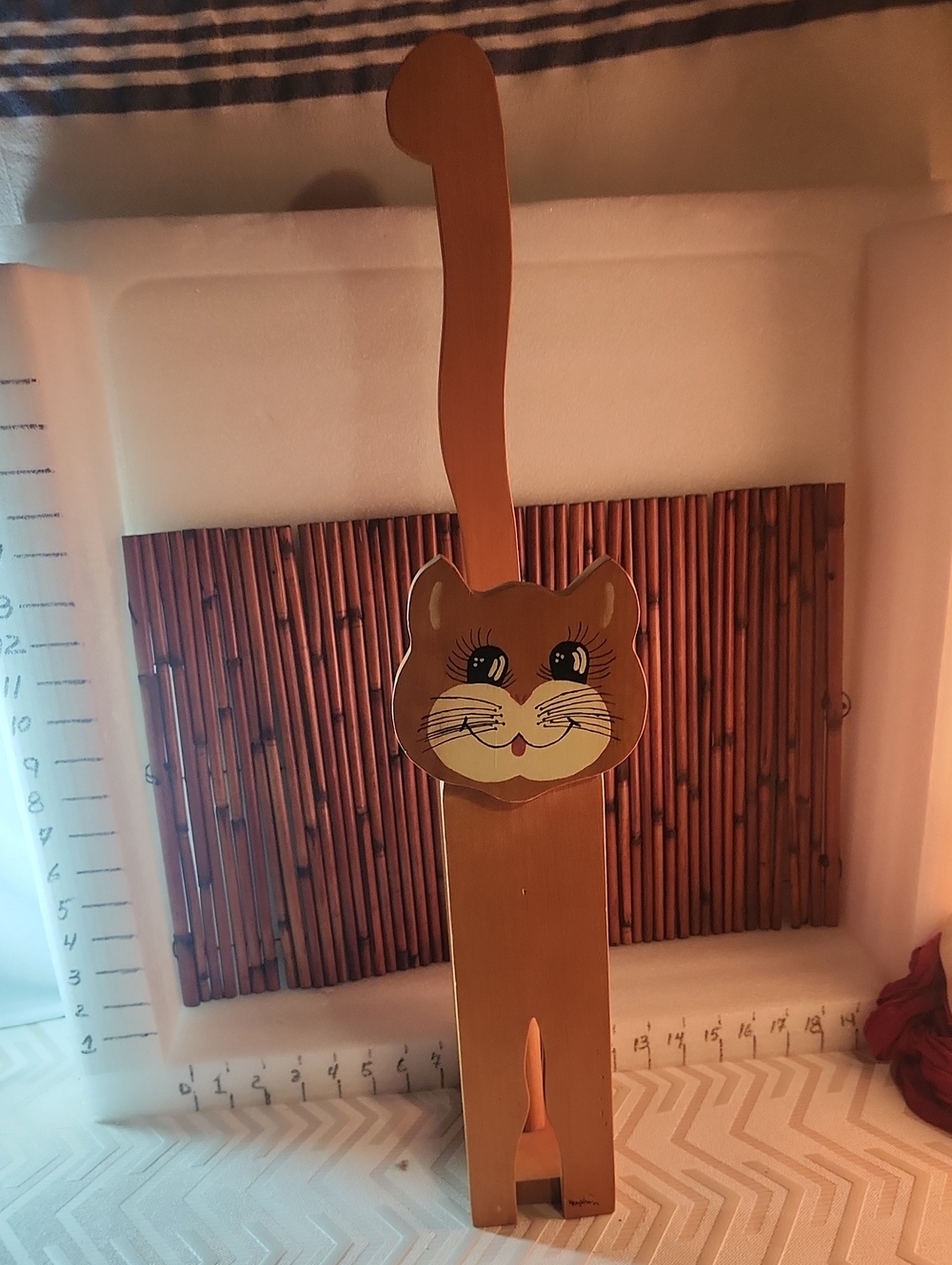 A stand or unwinder of wooden toilet paper in the shape of a cat.